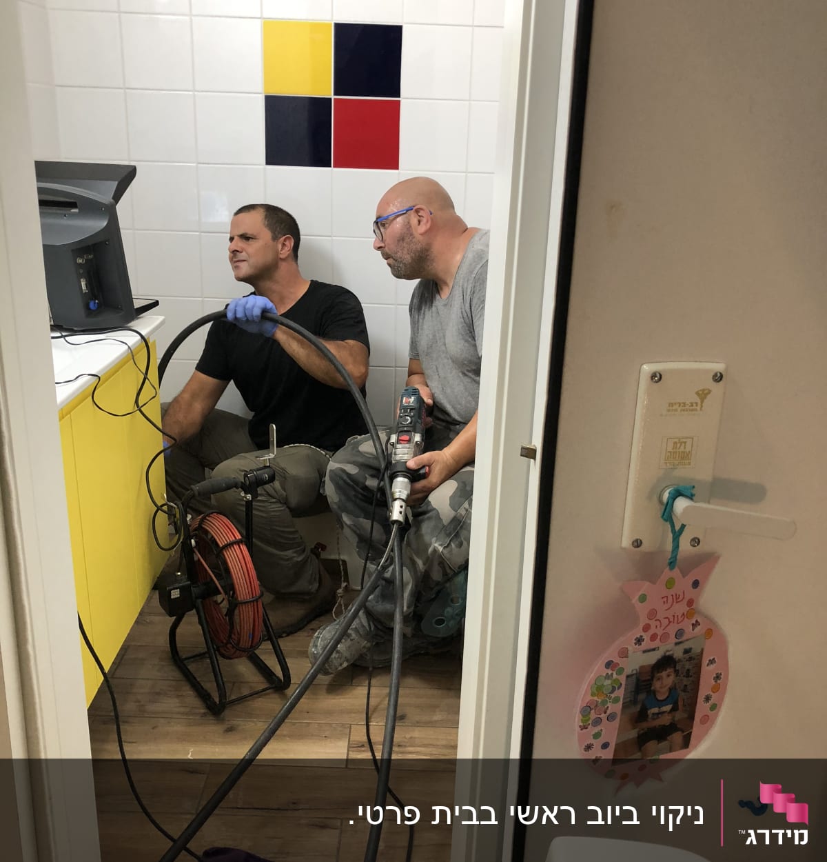 שני אנשים עובדים עם ציוד אינסטלציה בחדר אמבטיה